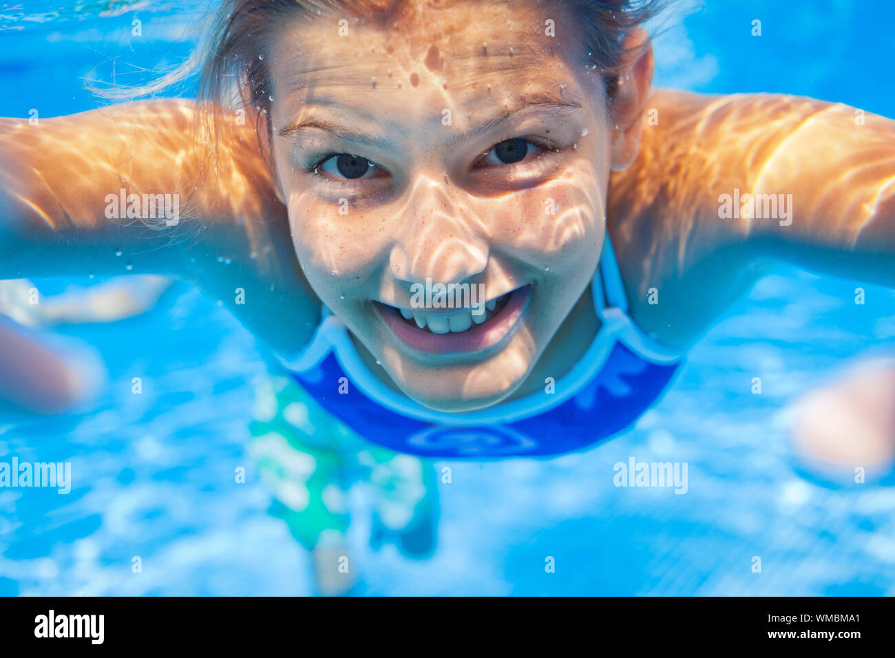 Close-up verticale di subacquea felice carina ragazza in piscina Foto Stock