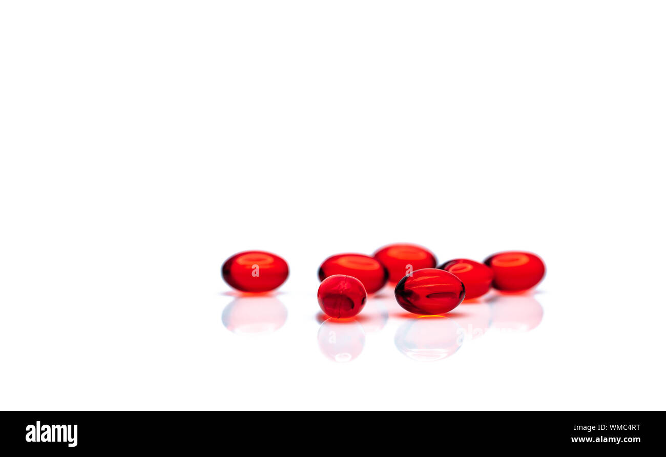 Morbido rosso capsula di gel pillole isolati su sfondo bianco. Pila di red capsule di gelatina morbida. Vitamine e integratori dietetici concetto. Prodotti farmaceutici Foto Stock