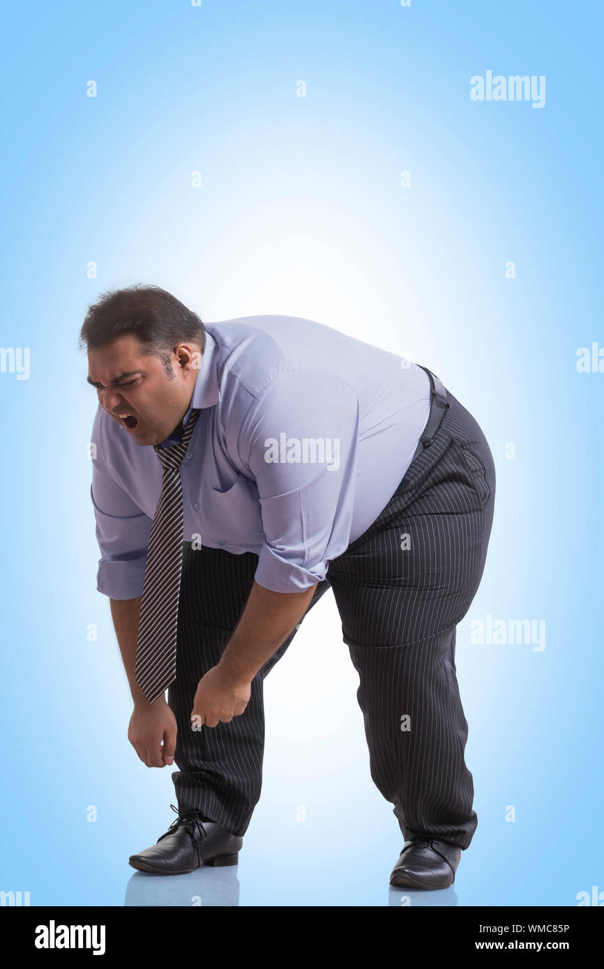 Uomo obesi in abiti formali di flessione in avanti il dolore Foto Stock