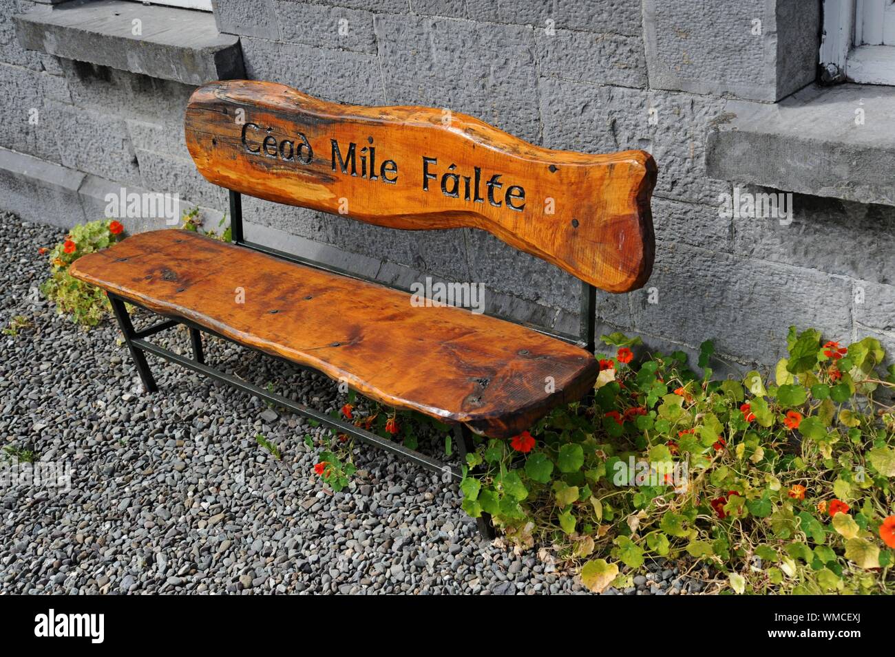 Una rustica panca in legno con la iscrizione intagliata Cead Mile Failte - mille accoglie con favore - in Oldham, Regno Unito Foto Stock