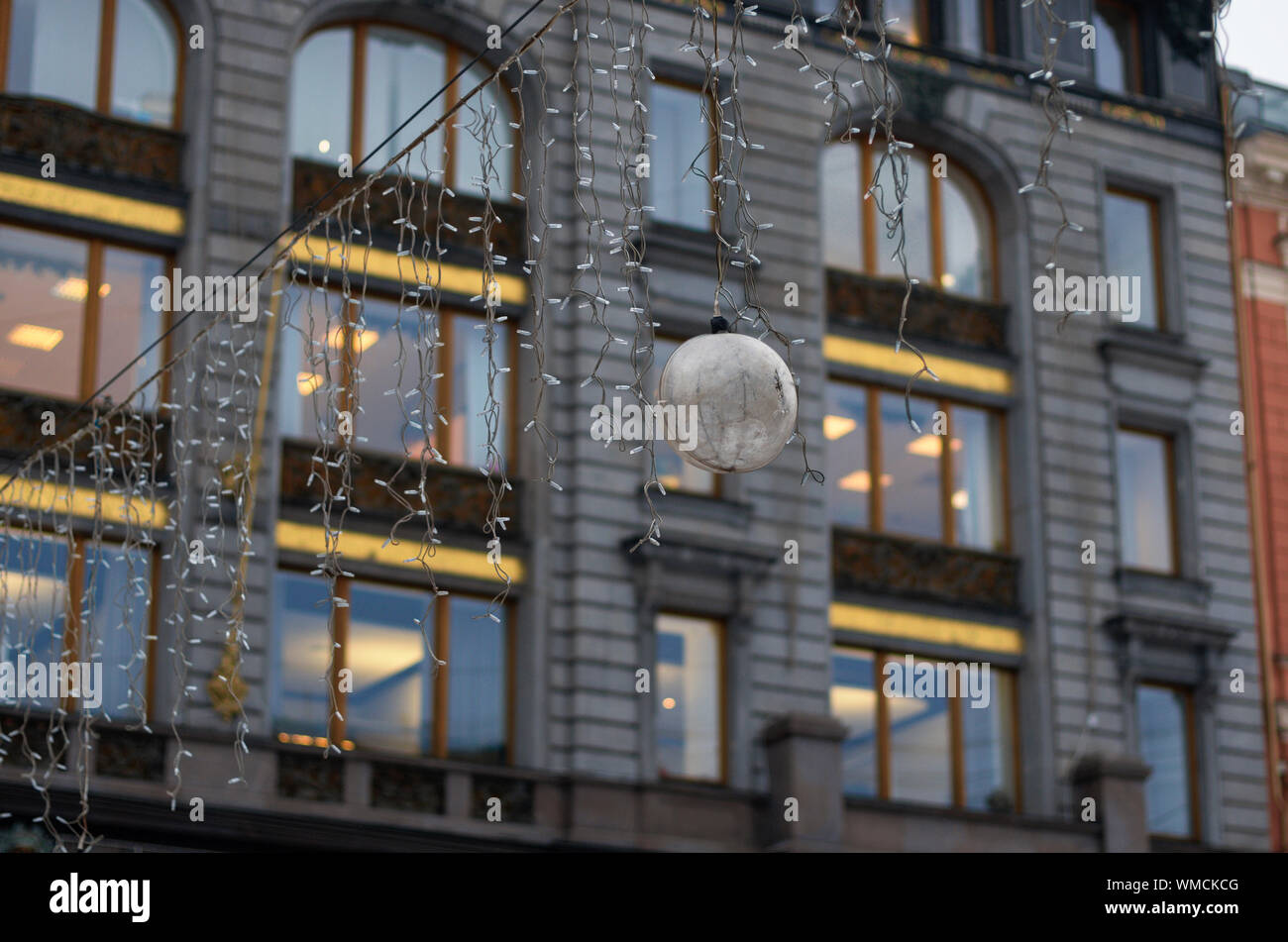 Appendere la ghirlanda con sfera su uno sfondo sfocato luci nelle finestre della facciata della casa cantante (St. Pietroburgo, Russia) Foto Stock