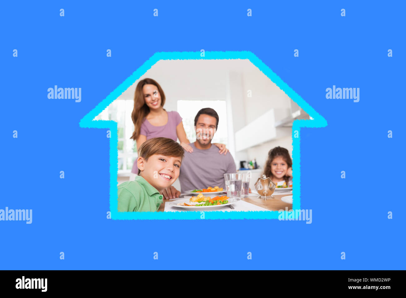 Famiglia guardando la telecamera a ora di cena contro il bollino blu Foto Stock