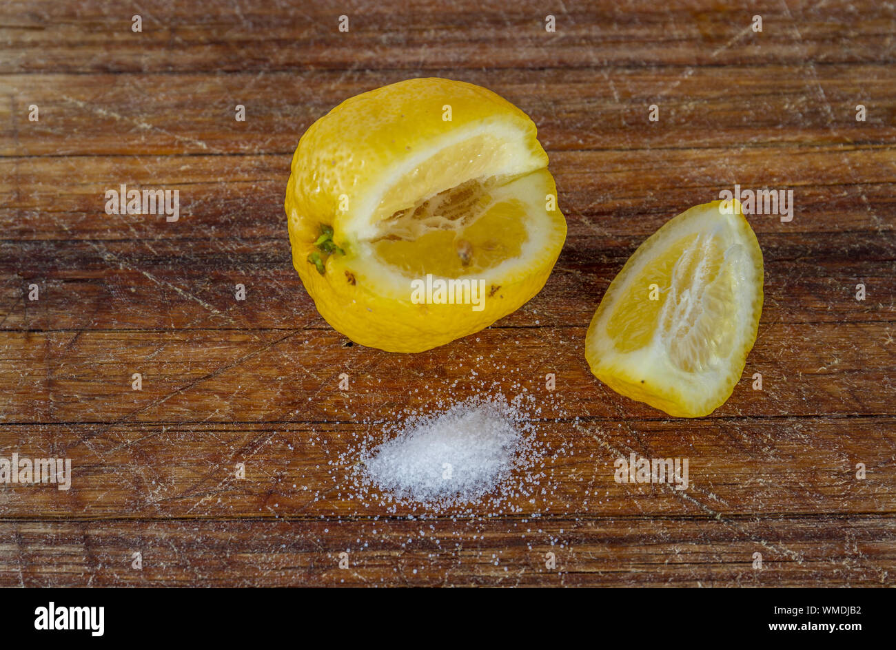Un limone a fettine e alcune sale su un tagliere di legno con immagine spazio copia in formato orizzontale Foto Stock