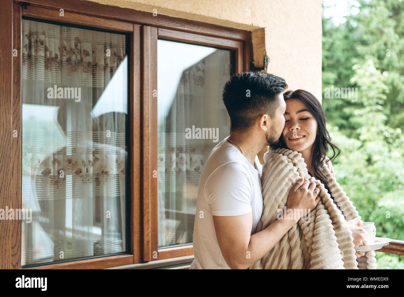 Un uomo baci e abbracci una donna sul balcone. Essi hanno una luna di miele  o chiudere il rapporto e l'amore Foto stock - Alamy