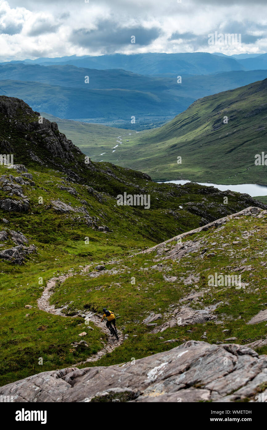 Un mountain biker cavalca un trail in Torridon Hills nel nord-ovest Highlands della Scozia. Foto Stock