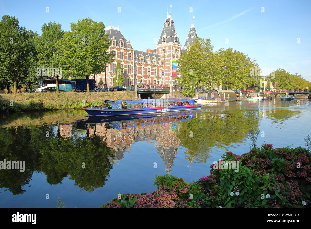 AMSTERDAM, Paesi Bassi - 22 agosto 2019: il Rijksmuseum riflessa in Lijnbaansgracht canal alle navi da crociera in primo piano Foto Stock