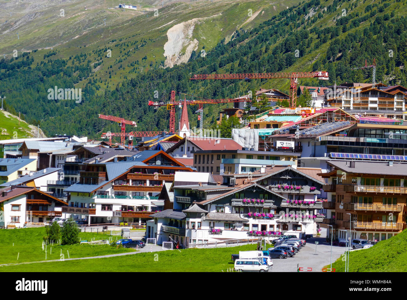 Gru e lavori di costruzione nelle montagne verdi e blu giornata di sole a Obergurgl, Ötztal, Austria, Foto Stock