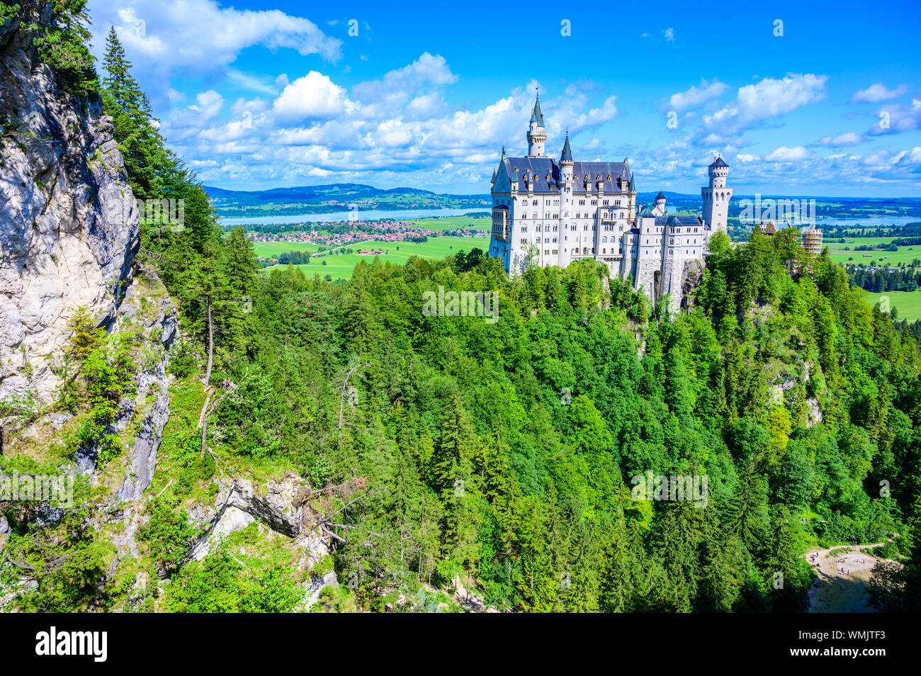 Il Castello di Neuschwanstein nel bellissimo paesaggio di montagna delle Alpi- sullo sfondo è possibile vedere il Lago di Forggensee - vicino a Füssen, Baviera, Germania Foto Stock