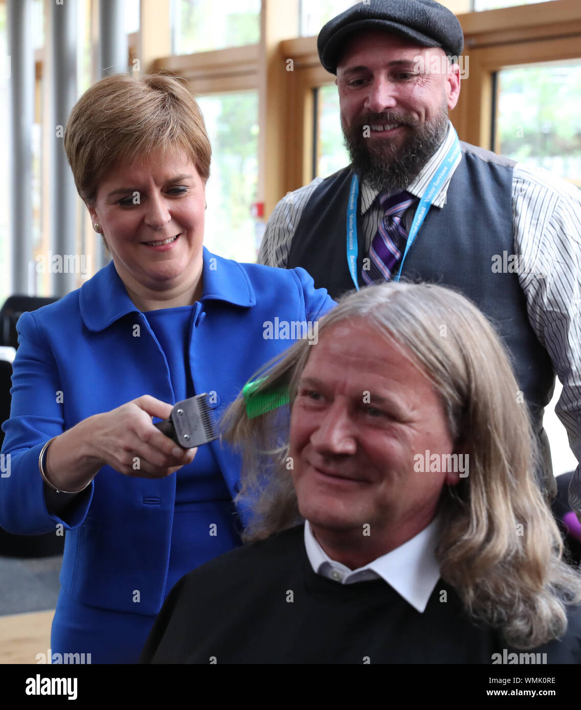 Primo Ministro Nicola Storione taglia i capelli di David Torrance MSP sollevamento £1000 per la carità Maggie's Centre in Kirkcaldy presso il parlamento scozzese di Edimburgo. Foto di PA. Picture Data: giovedì 5 settembre 2019. Foto di credito dovrebbe leggere: Andrew Milligan/PA FILO Foto Stock
