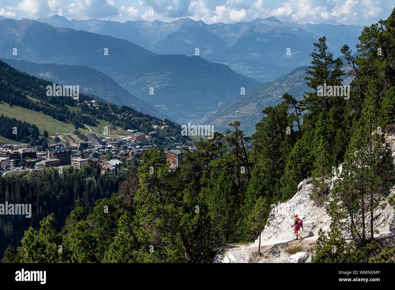 Una donna passeggiate su un sentiero di cresta in alta quota su Dent du Villard vicino a Courchevel nelle Alpi francesi. Foto Stock