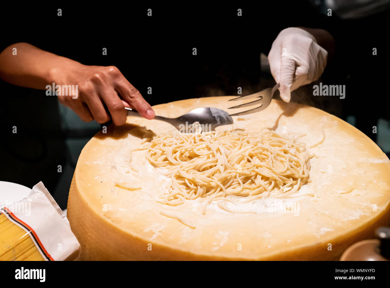 Lo chef cucinare la pasta nella ciotola di formaggio Foto Stock