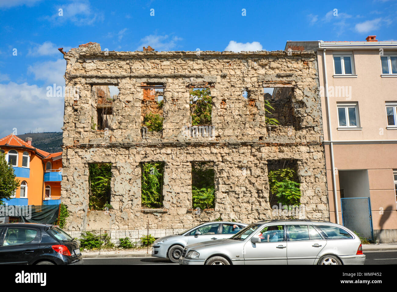 Un edificio giace abbandonata dopo essere stato distrutto durante la guerra dei Balcani nella città di Mostar, Bosnia Erzegovina Foto Stock