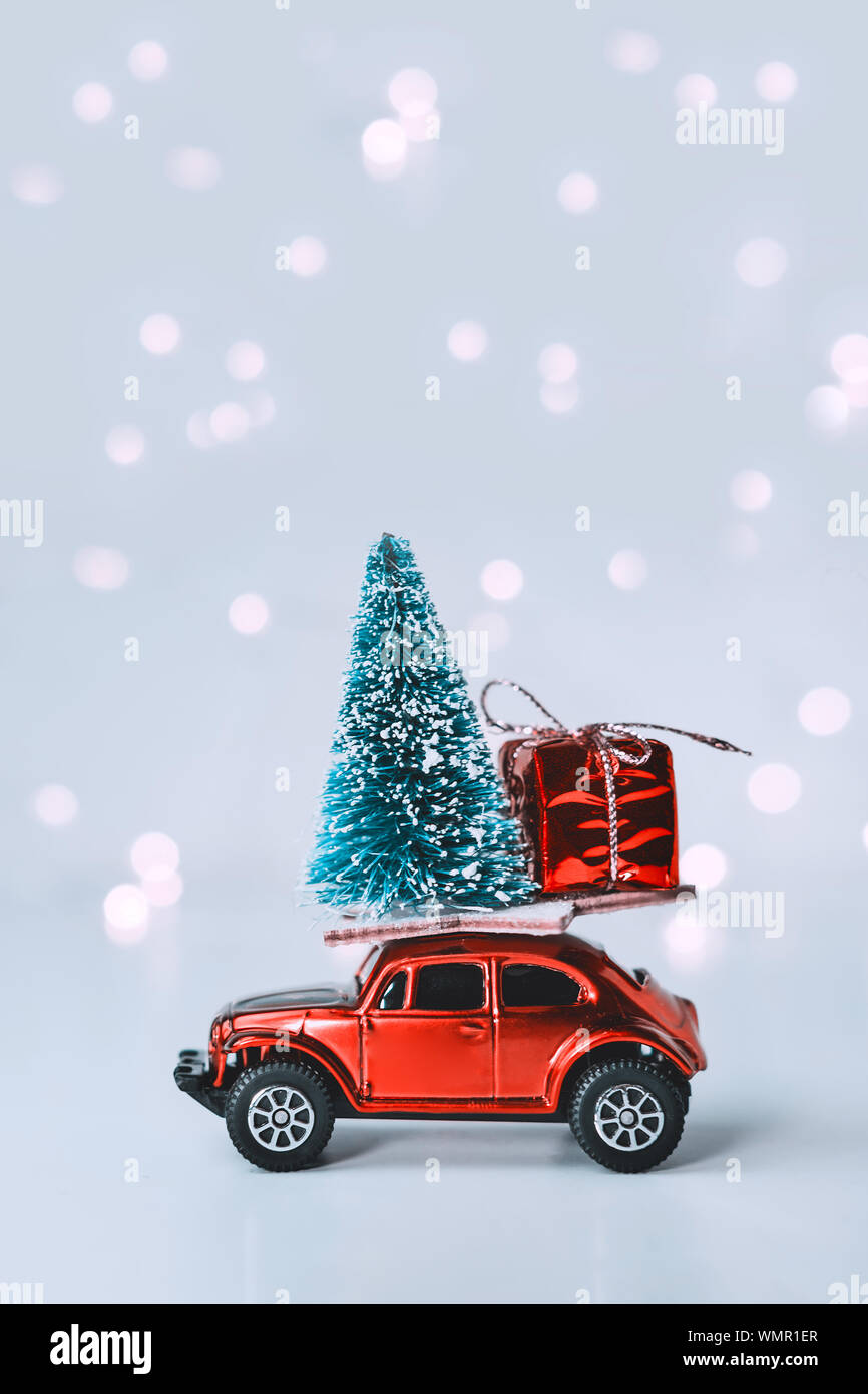 Macchina giocattolo con albero di Natale e regali sul tetto. Sullo sfondo di  un bokeh offuscata da garland. Nuovo anno e vacanze di Natale concept Foto  stock - Alamy