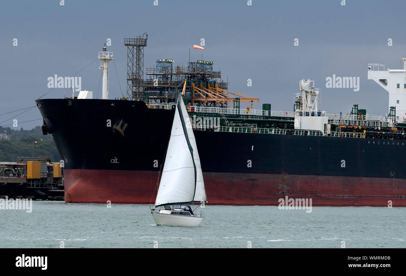 Southampton acqua, Inghilterra, Regno Unito, settembre 2019. Chimica, prodotti olio di navi cisterna per il trasporto di carico off cargo presso una raffineria. Una barca vela passato questo grande nave Foto Stock