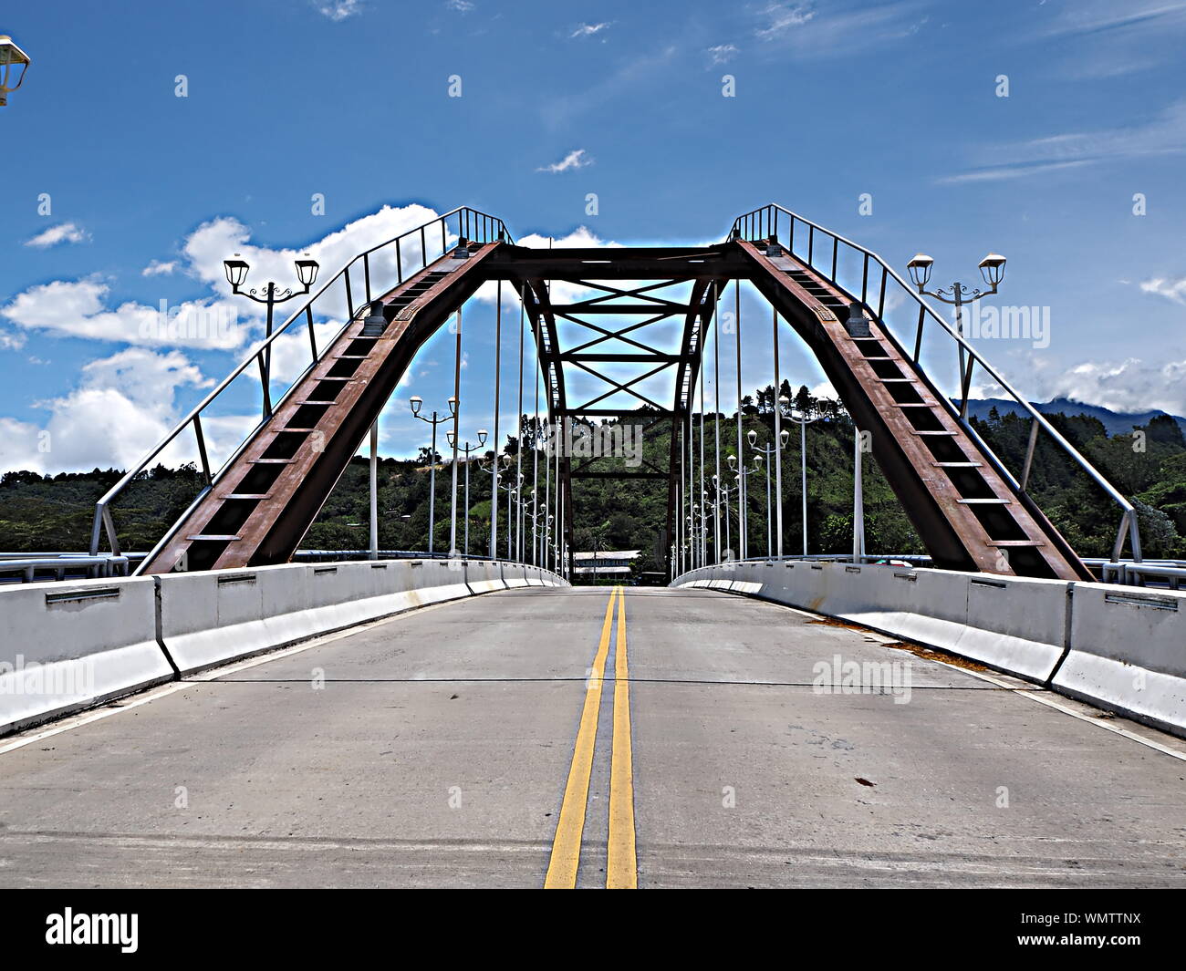 Strada sospesa ad arco in acciaio e ponte pedonale sul fiume Caldera a Boquete, Panama Highlands. Foto Stock