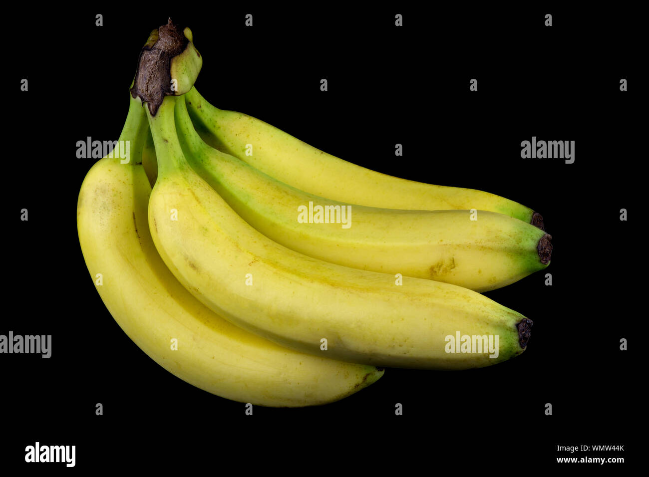 Un grappolo di banane isolata contro uno sfondo nero Foto Stock