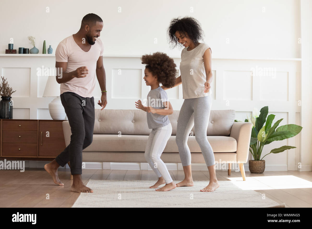 Felice famiglia americana africana divertendosi, dancing a casa. Foto Stock