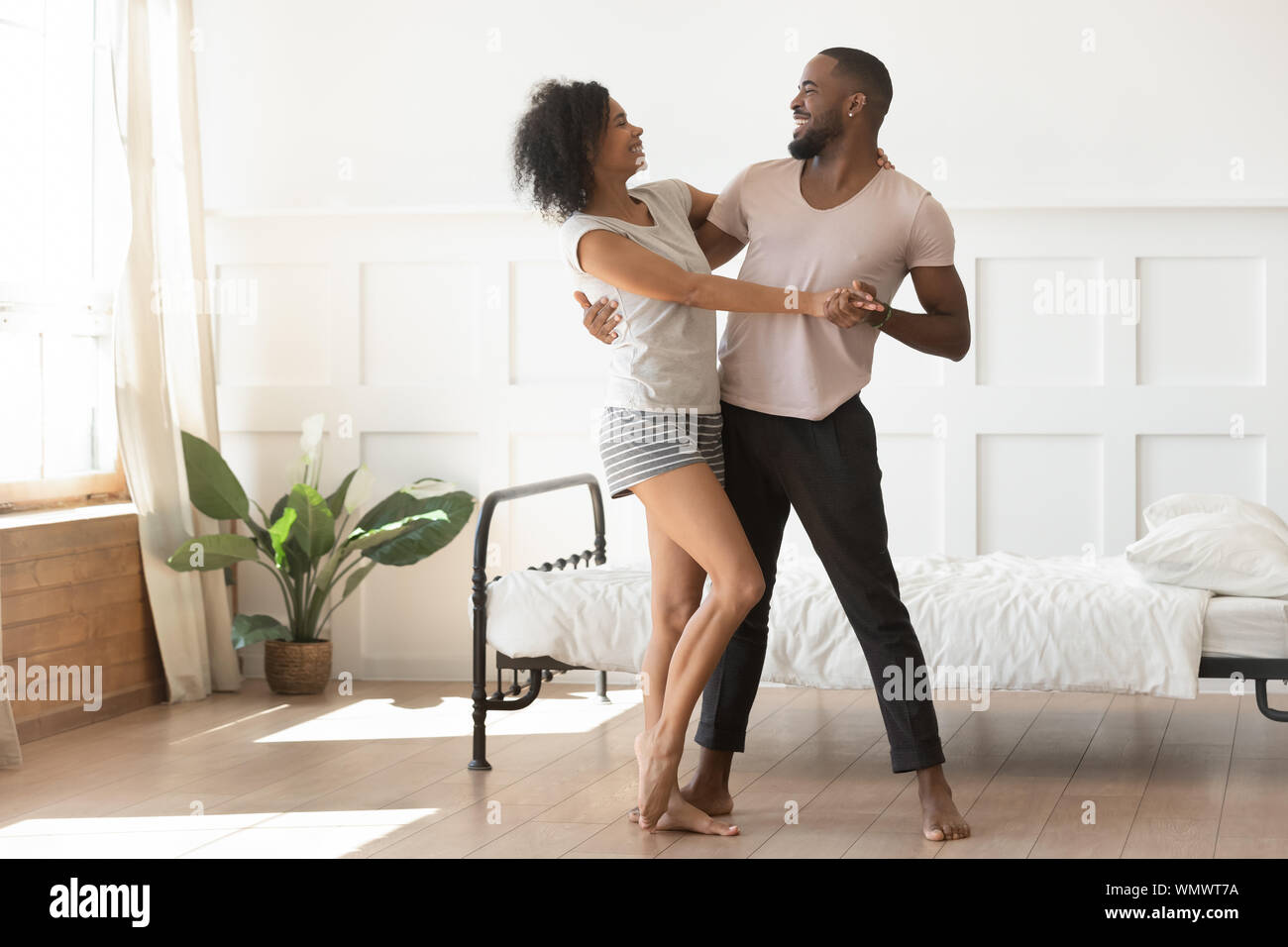 Felice famiglia americana africana coppia danzante in camera da letto. Foto Stock