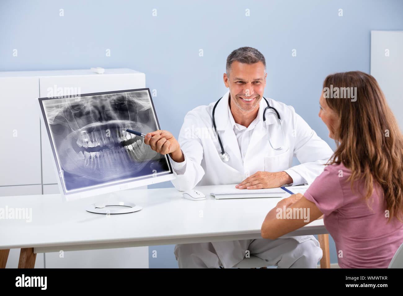 Dentista spiegando che mostra Panorama dentale X-ray per donna Foto Stock