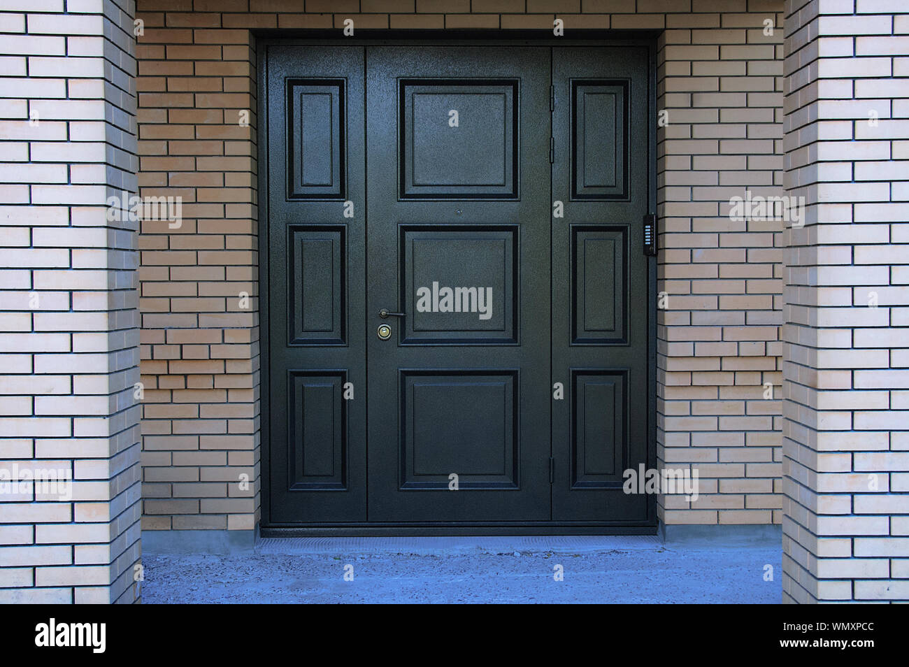 Metallo nero porta di ingresso in una casa di mattoni. Foto Stock