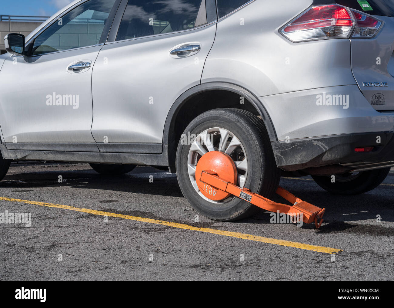 Auto parcheggiata immobilizzato con orange morsetto di parcheggio o di boot Foto Stock