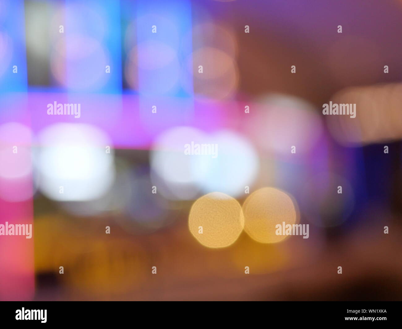 Bokeh da illuminazione per interni, colorati cerchi di luce diffusa sul blu con il giallo arancio e il colore di sfondo per la celebrazione delle feste Foto Stock