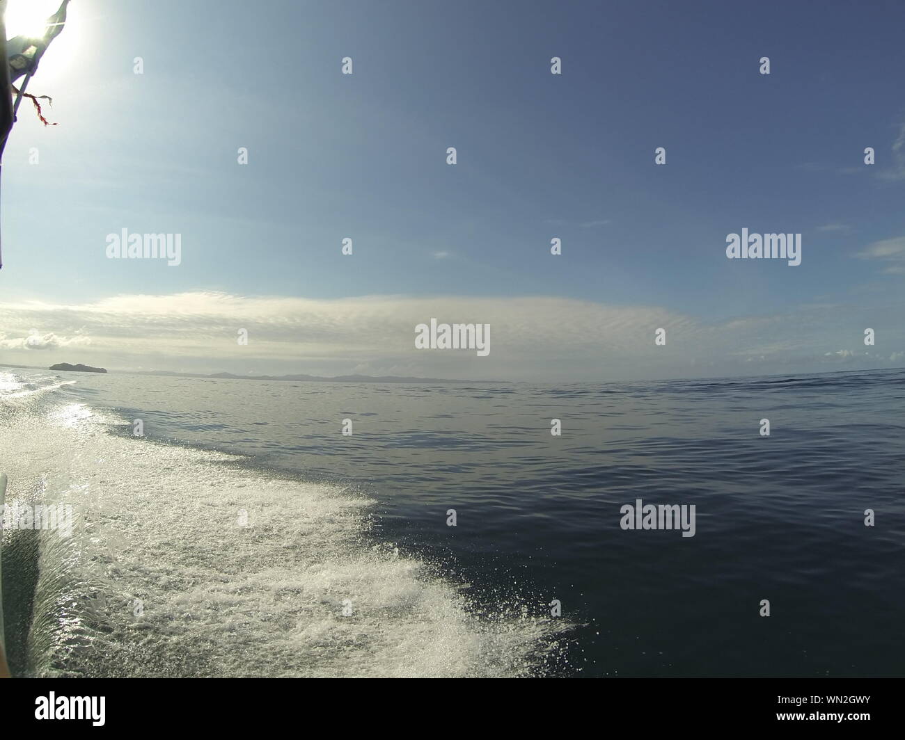 l'oceano calmo piatto. al mare in una barca con cielo blu e mare. onda di prua dalla barca Foto Stock