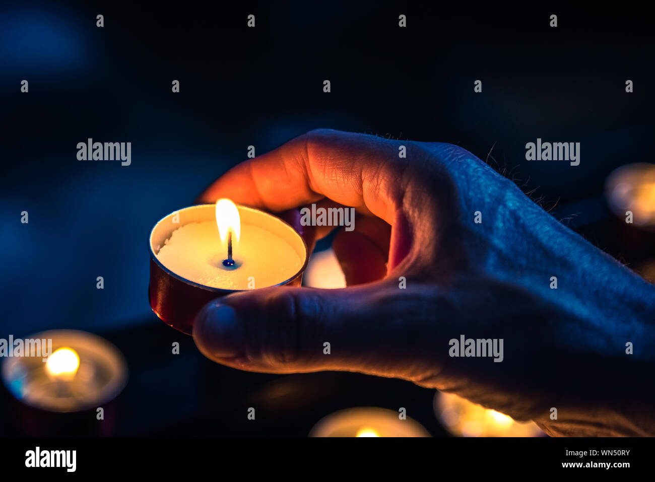 Close-up della mano che tiene accesa candela Foto stock - Alamy