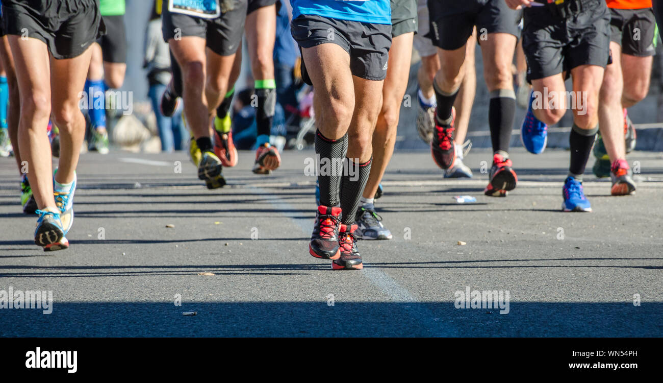 Asfalto con fondo delle gambe dei corridori durante la maratona di Valencia Foto Stock