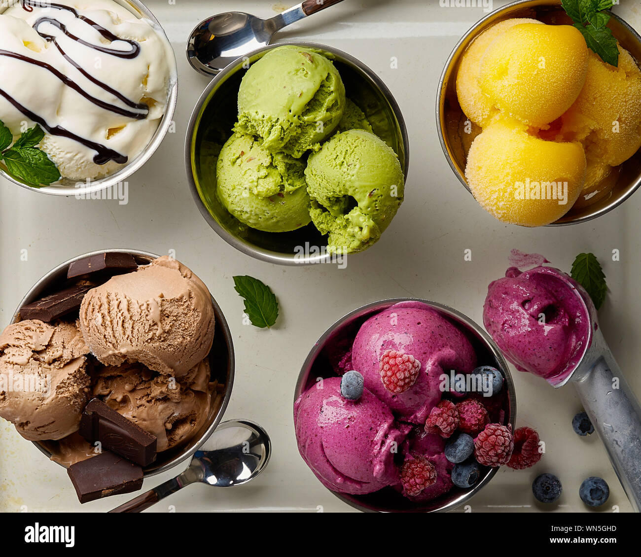 Un assortimento di sapori e colori di gourmet gelato italiano servito sul tavolo in acciaio. Mango, cioccolato, Verde matcha ice cream Foto Stock