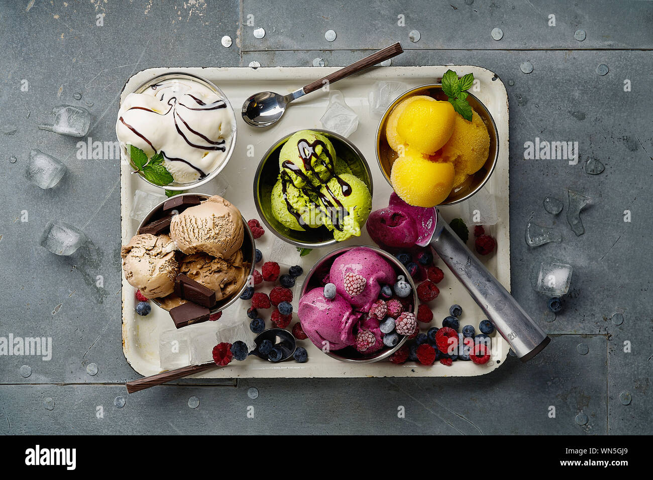 Un assortimento di sapori e colori di gourmet gelato italiano servito sul tavolo in acciaio. Mango, cioccolato, Verde matcha ice cream Foto Stock