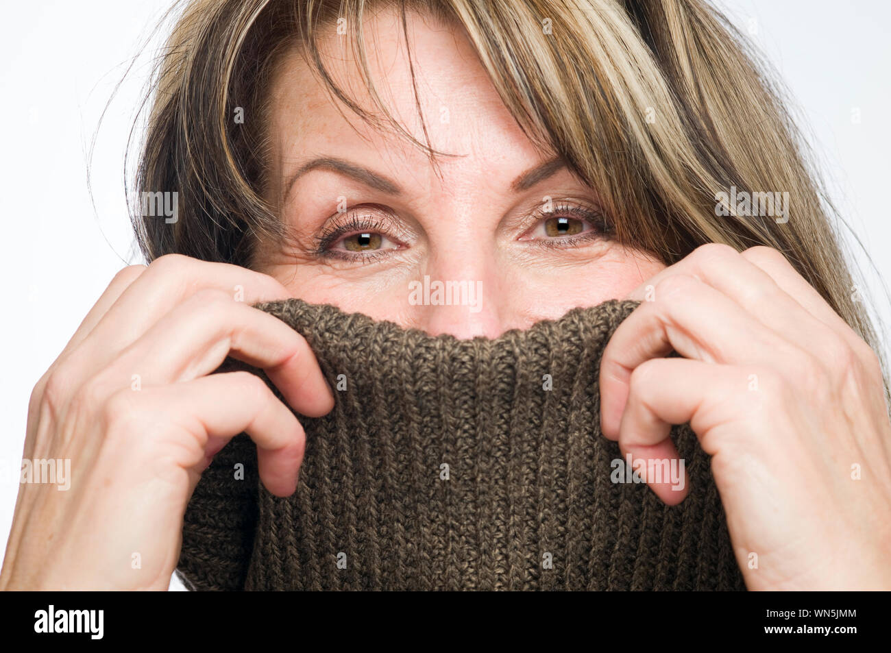 Ritratto di metà donna adulta che ricopre la faccia con Turtleneck maglione Foto Stock