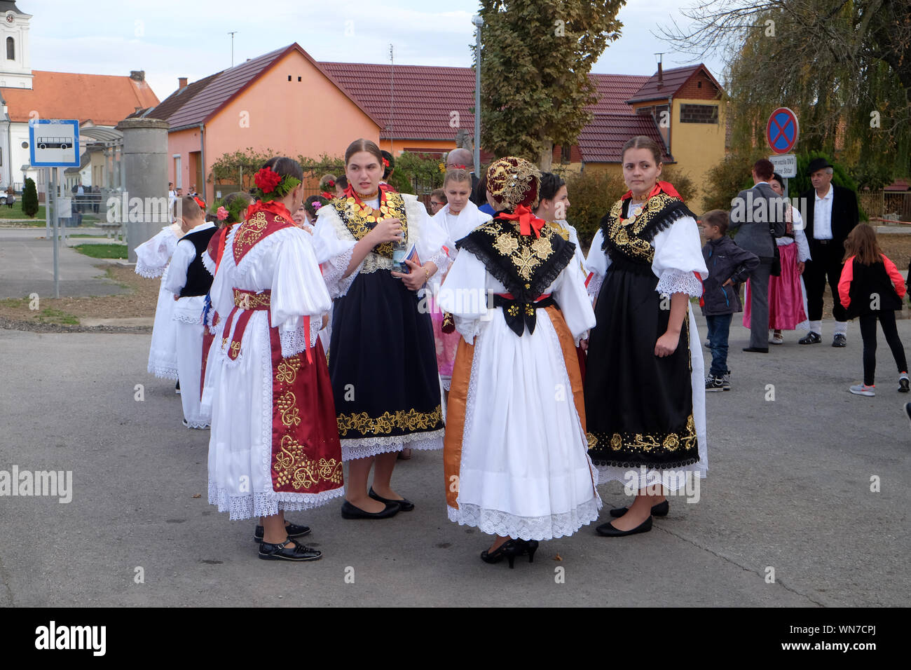 Ragazze vestito in costumi folcloristici andare in chiesa durante la Santa Messa il giorno del Ringraziamento in Stitar, Croazia Foto Stock