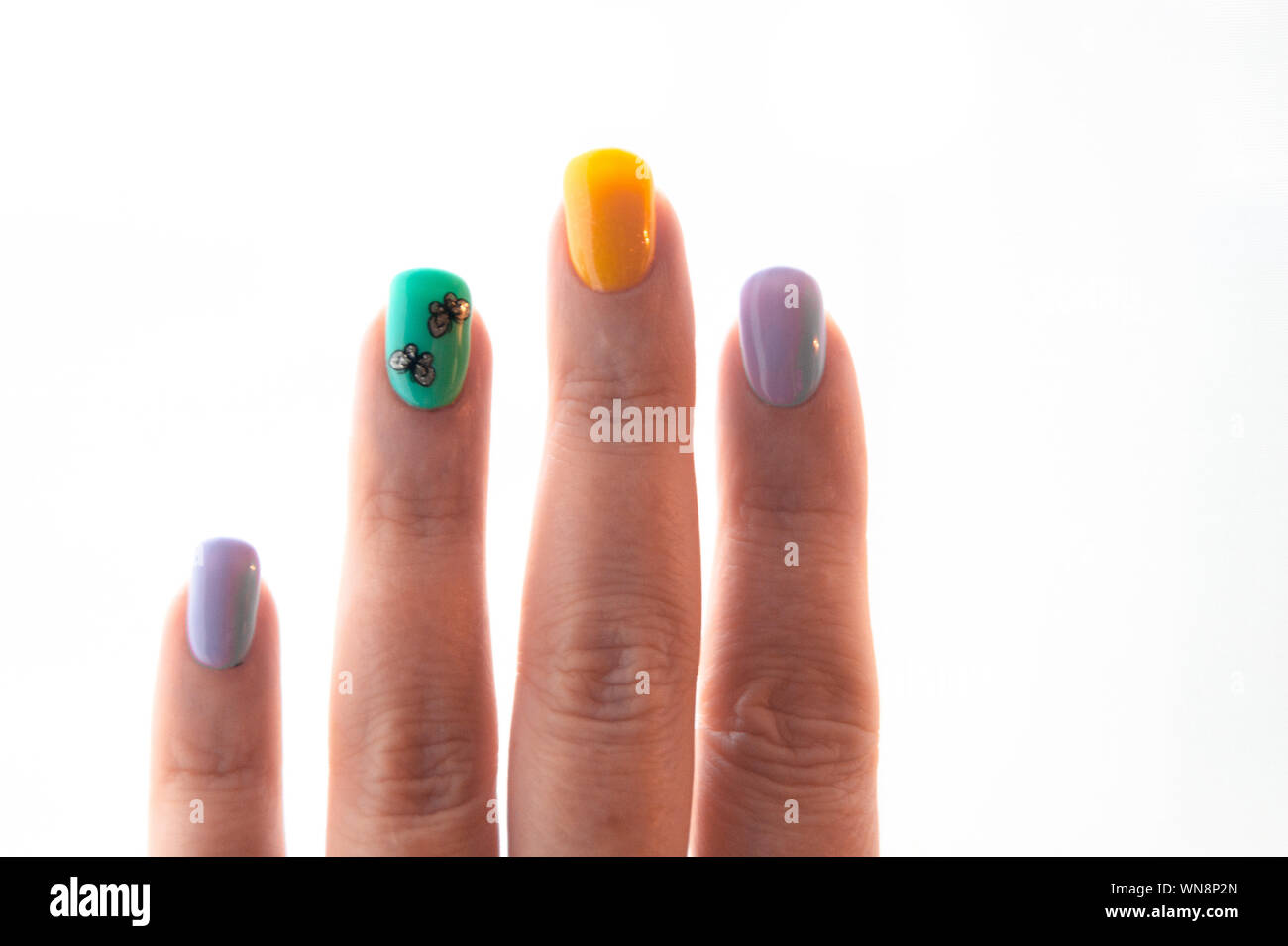 Manicure - gel polish in colori luminosi toni estivi, le farfalle sono incollati su un chiodo - foto. La gommalacca, unghie mani. Cura del viso, glamour Foto Stock