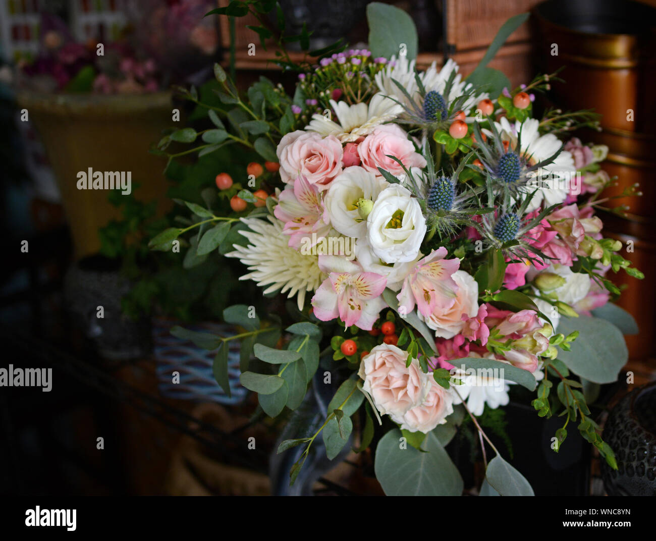 Bouquet nuziale traboccante di rose, cardo, COSMO, bacche di Hypericum, fuji mamme, garofani, lisianthus, Silver Dollar eucalipto, ecc. Foto Stock