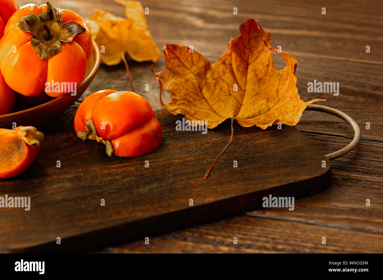 Persimmons maturi su uno sfondo di legno. Persimmon varietà Fuyu. Close-up. Foto Stock