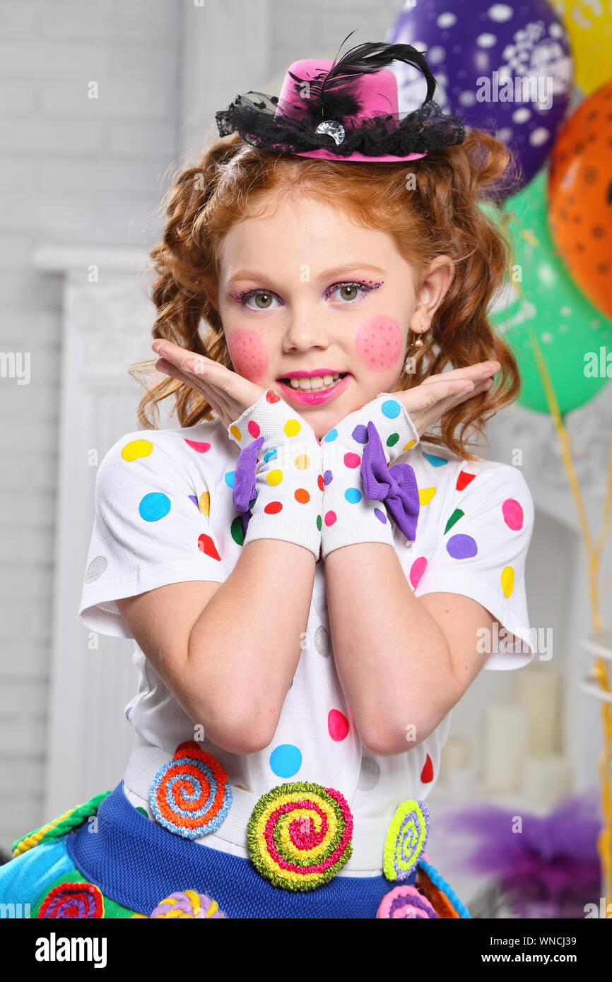 Una bambina di colore luminoso abiti di carnevale, con luminosi per il make-up. Foto Stock