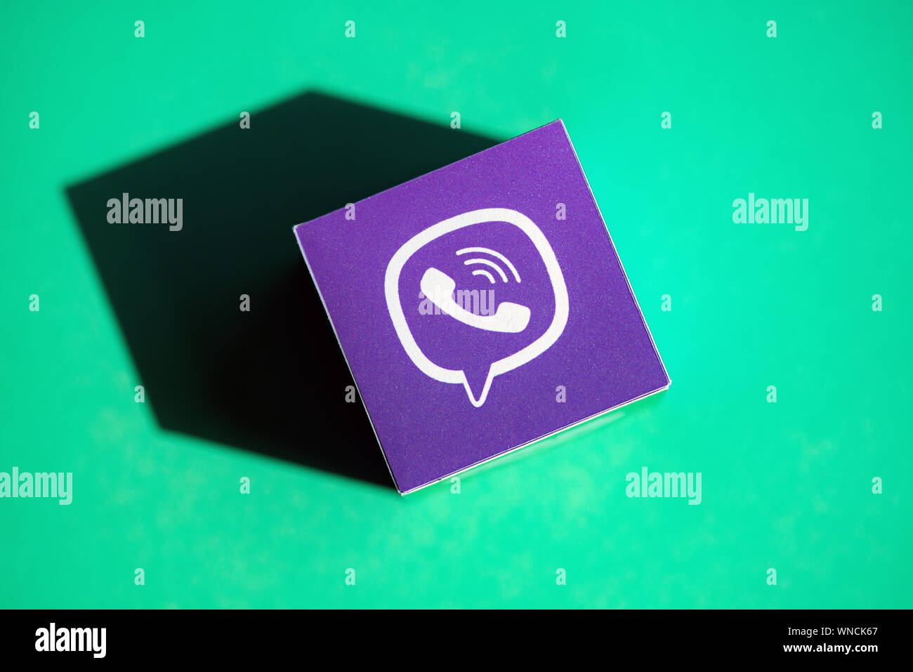 Un colpo dal di sopra del cubo di carta con il logo stampato dell'applicazione Viber, che posto su uno sfondo verde. Foto Stock