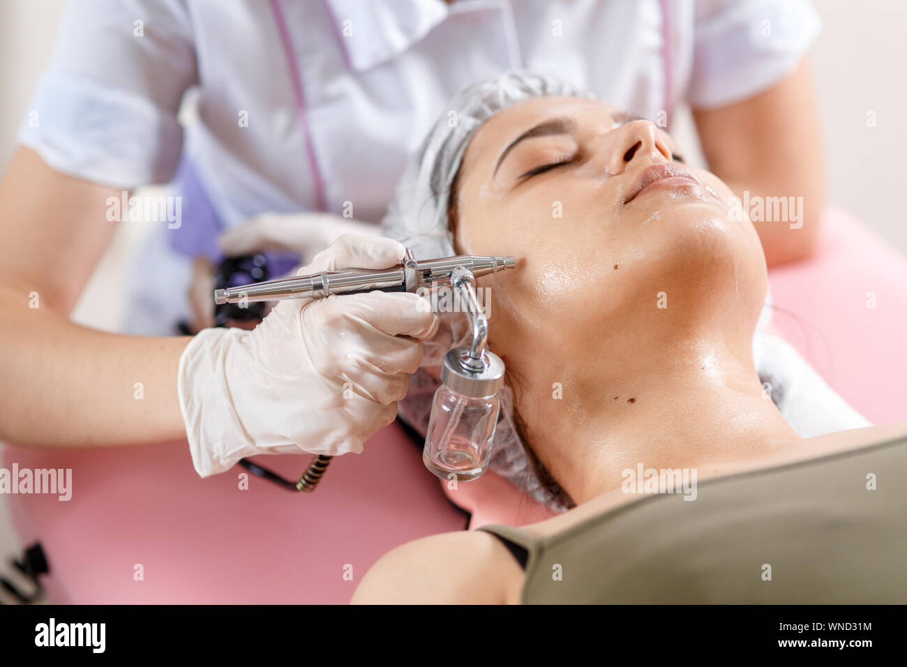 La cosmetologia clinica di bellezza.Professional cosmetologo conduce l'ossigenazione delle cellule per il viso trattamento con ozono con la cosmetologia apparat. Fisioterapia. Effetto di sollevamento . Foto Stock