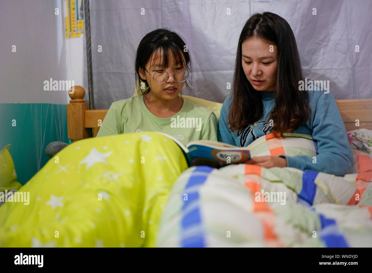 (190906) -- CHONGQING, Sett. 6, 2019 (Xinhua) -- Mu Yi (R) e Tao Yao condividere esperienze di insegnamento nel loro dormitorio a Lianhua scuola primaria di Luzi Village, Chengkou County, a sud-ovest della Cina di Municipalità di Chongqing, Sett. 3, 2019. Mu Yi, un 25-anno-vecchio insegnante PE dalla Municipalità di Chongqing, offre una settimana di volontariato servizio di insegnamento e le opere di un maestro locale Tao Yao in questo remoto villaggio. Nella scuola dove solo due di secondo grado studenti e 18 bambini di età prescolare studio, Mu Yi e Tao Yao anche fare altri lavori come mandanti, detergenti, i cuochi e repairwomen. Mu Yi insegna ai bambini sport Foto Stock