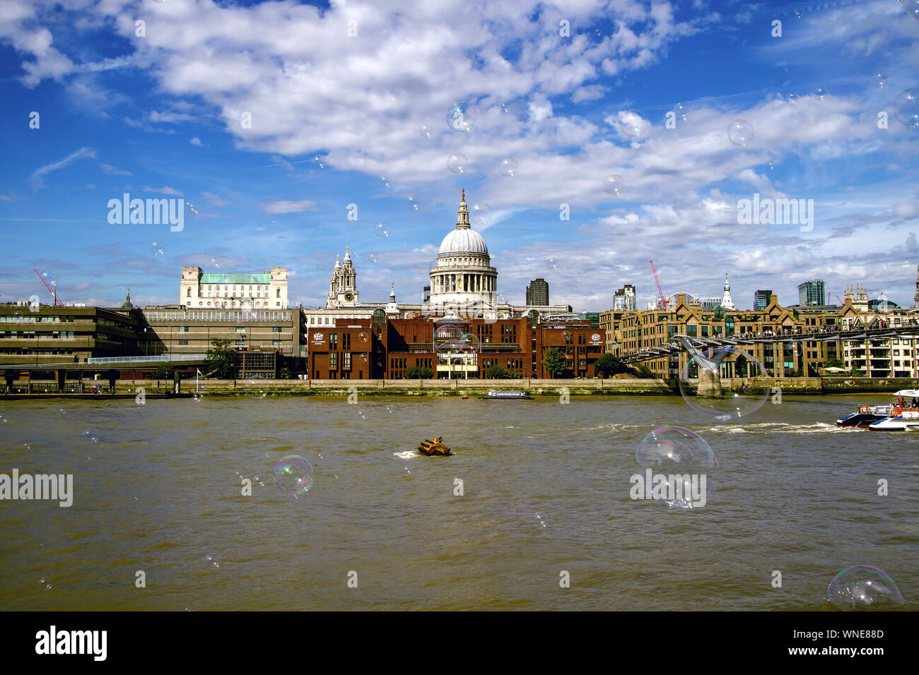 Città di Londra (compresi Cattedrale di San Paolo) attraverso il Fiume Tamigi alla Tate Modern di Londra, Inghilterra, con bolle da un esecutore di strada Foto Stock