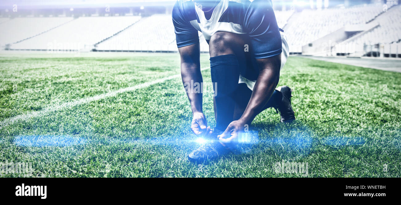 African American maschio giocatore di rugby di legatura di lacci delle scarpe nel Stadium Foto Stock