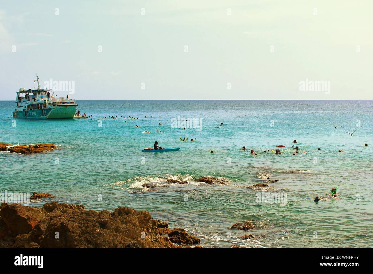 19 agosto 2019: un grande gruppo di turisti e villeggianti snorkeling nel mare intorno al popolare destinazione turistica di Maho Beach, St Maarten. Foto Stock