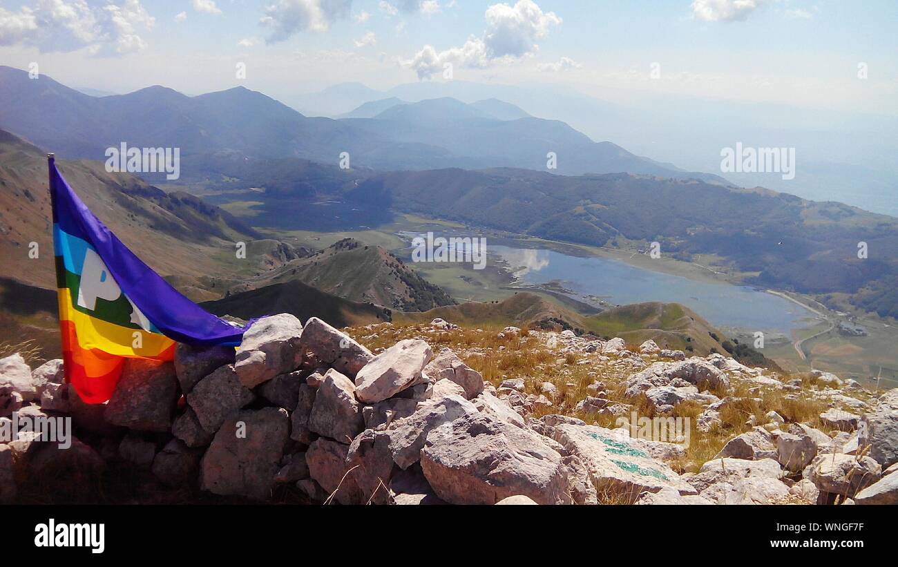 Bandiera arcobaleno su pietra con montagne visto in background Foto Stock