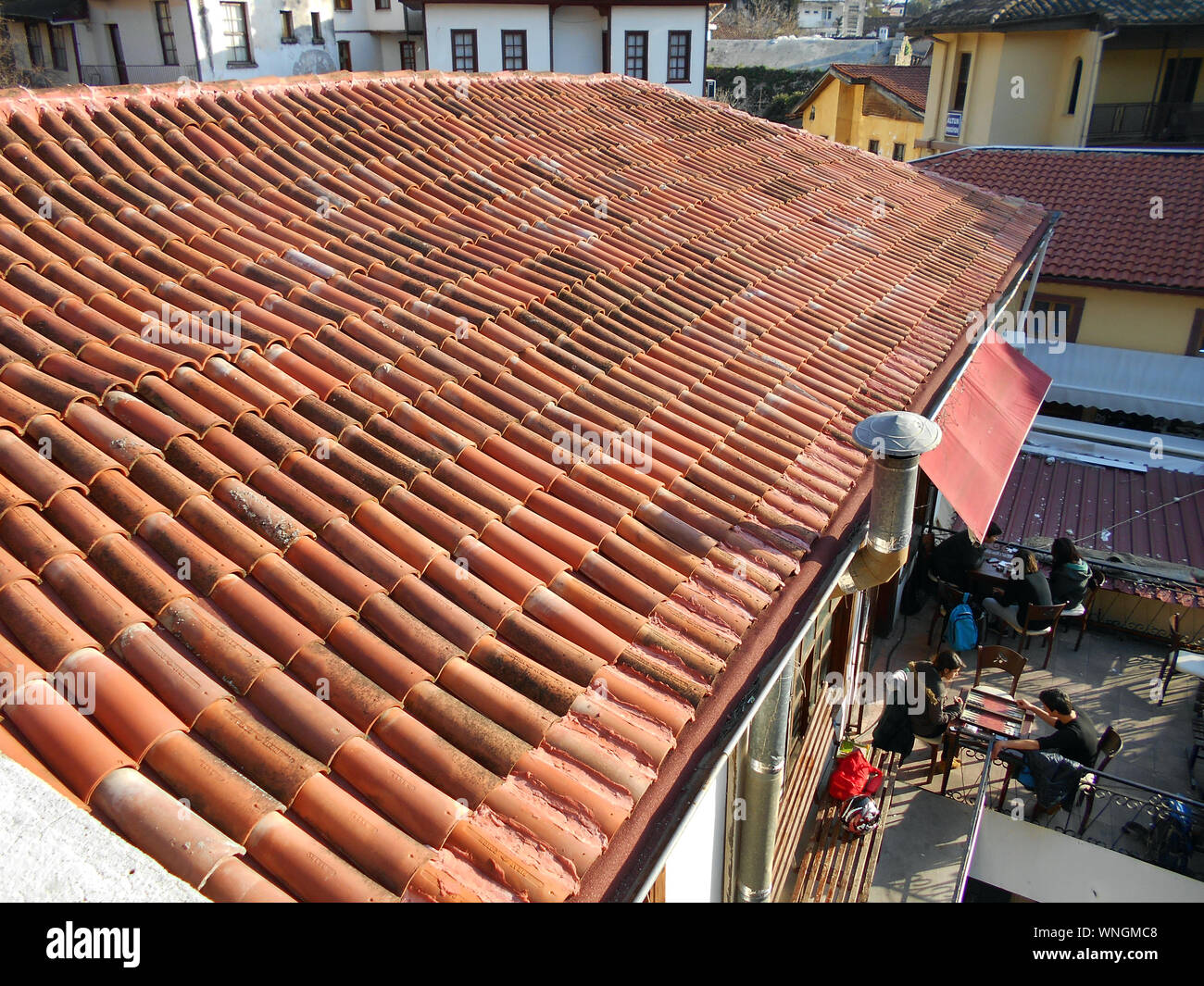 Una splendida terracotta tetto di tegole su un cafe/bar stabilimento nel lato mare città di Antalya in Turchia. Il marrone rossiccio e tetto sembra buona sotto il sole come i clienti di giocare a backgammon all'esterno. Alan Wylie © /ALAMY Foto Stock