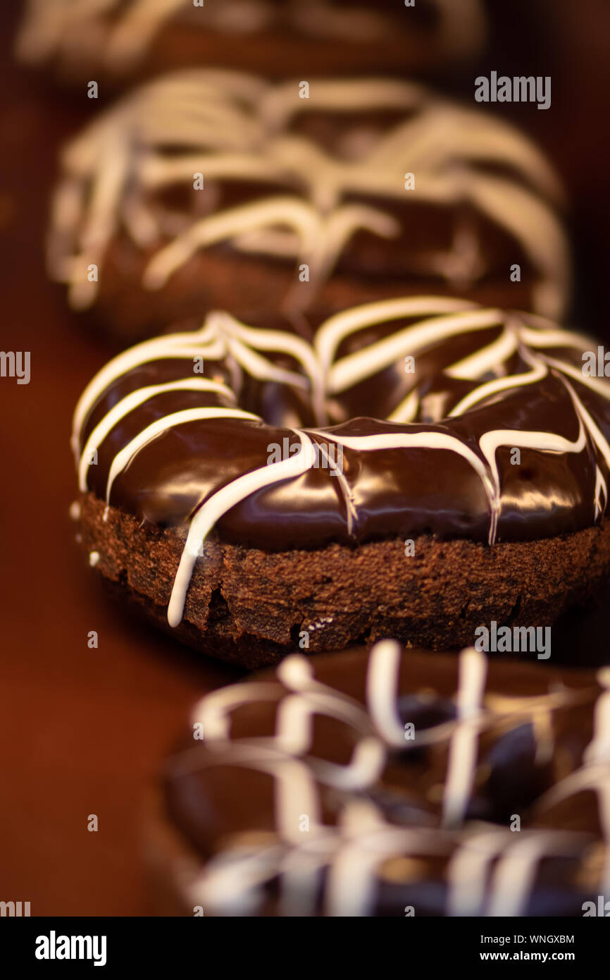 Close up di deliziose ciambelle al cioccolato sullo sfondo Foto Stock