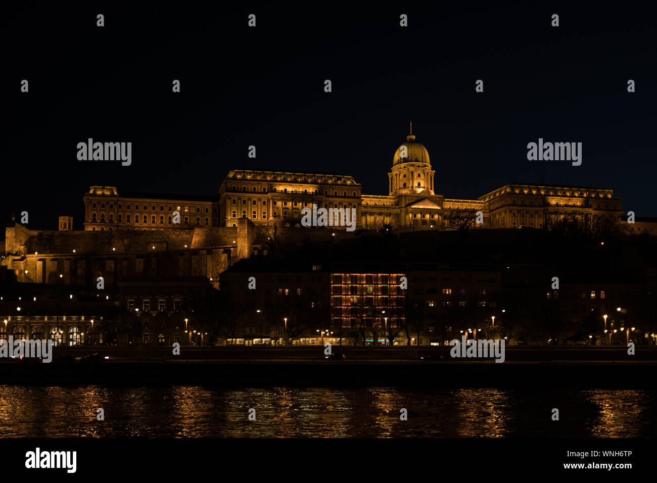 Illuminato il castello di Buda durante la notte, una vista dal fiume Danubio. Foto Stock