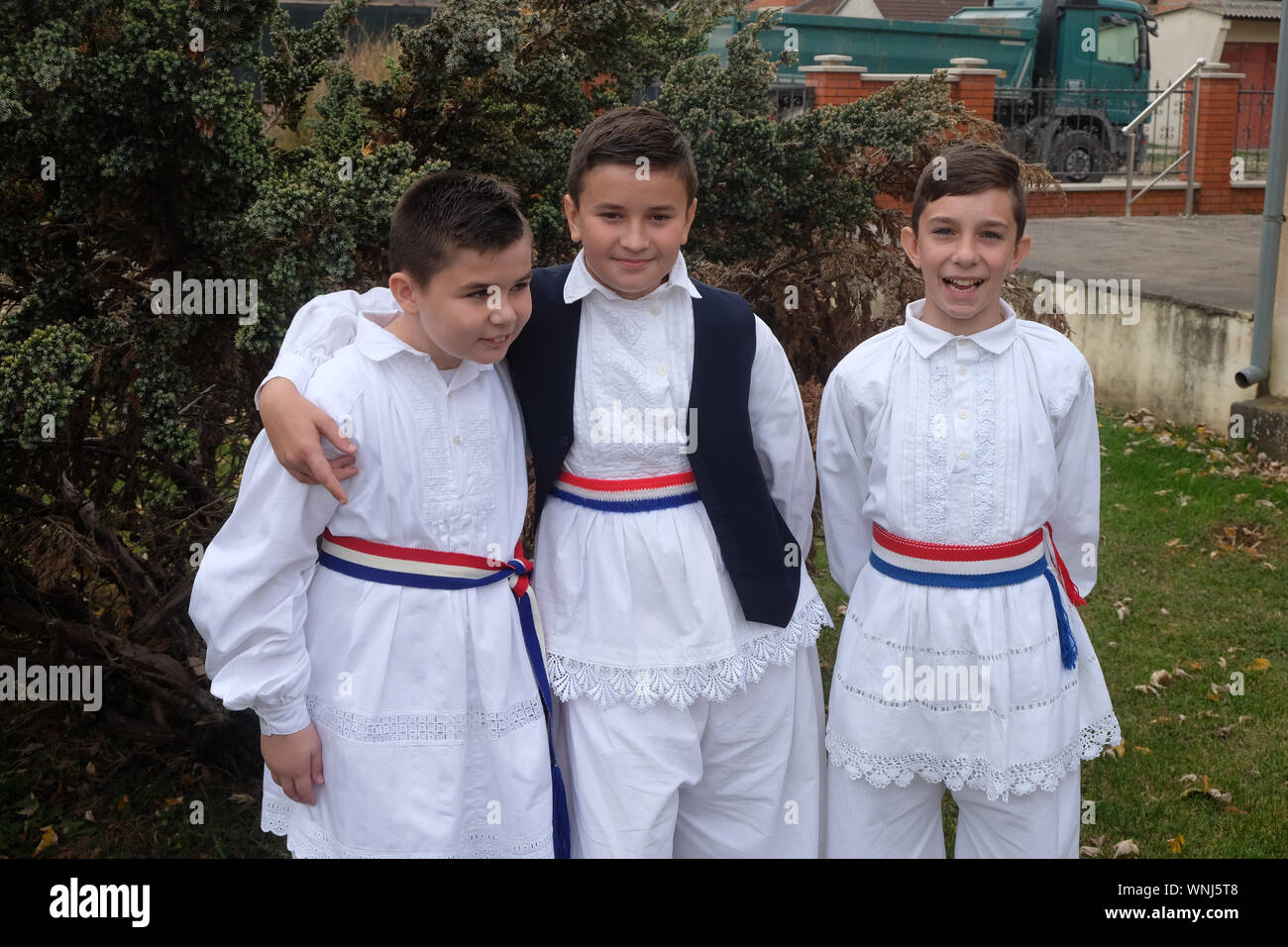 Ragazzi vestito in costumi folcloristici andare in chiesa durante la Santa Messa il giorno del Ringraziamento in Stitar, Croazia Foto Stock