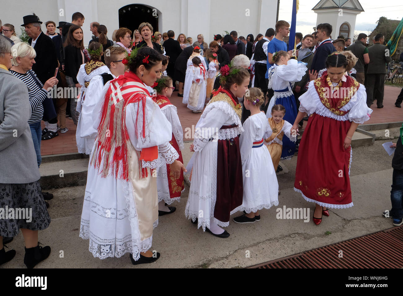 Persone vestite in costumi folcloristici andare in chiesa durante la Santa Messa il giorno del Ringraziamento in Stitar, Croazia Foto Stock