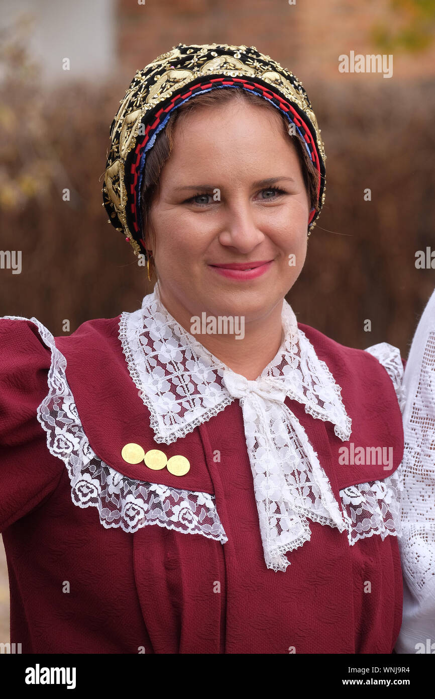 Donna vestito in costumi folcloristici andare in chiesa durante la Santa Messa il giorno del Ringraziamento in Stitar, Croazia Foto Stock
